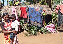 Chengalpuddar village woman and child by their home – FOH helped form a women's self–help group producing herbal medicines & oils Village women and child by home and washing line